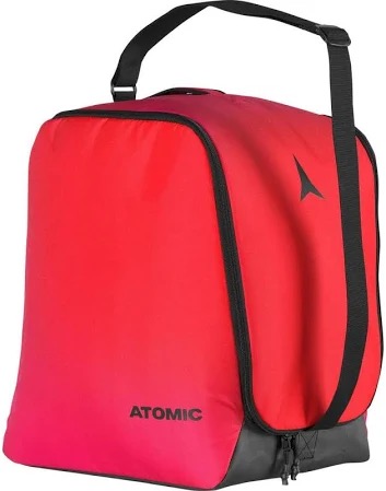 Rote Atomic Skischuhtasche mit schwarzem Tragegurt und Reißverschluss am grauen Boden. Das Atomic-Logo ist auf der Seite.