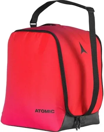Rote Atomic Skischuhtasche mit schwarzem Tragegurt und Reißverschluss am grauen Boden. Das Atomic-Logo ist auf der Seite.