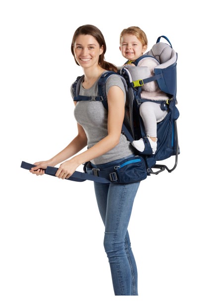 Woman with child carrier Kid Comfort Active in Midnight color with child on her back, carrying straps are put on.