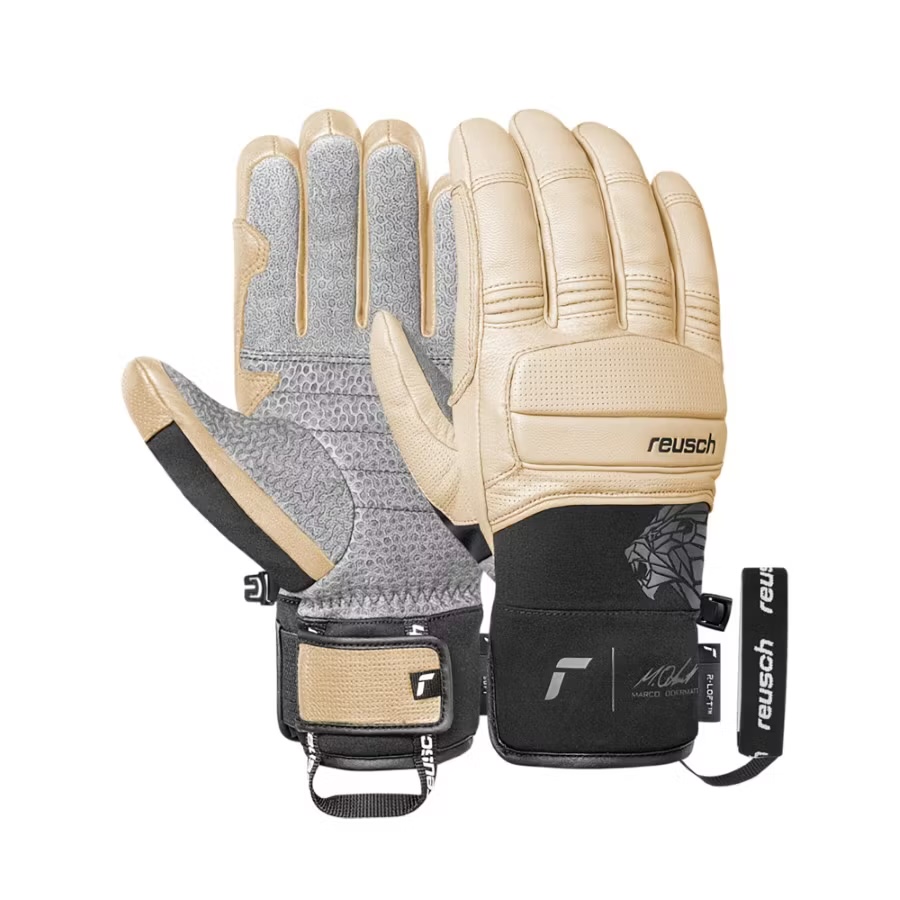 Beige Reusch-Skihandschuhe mit schwarzem Handgelenkband und sichtbaren Handflächen mit Textur. Ein Paar Handschuhe mit Markenlogo und Namenszug.