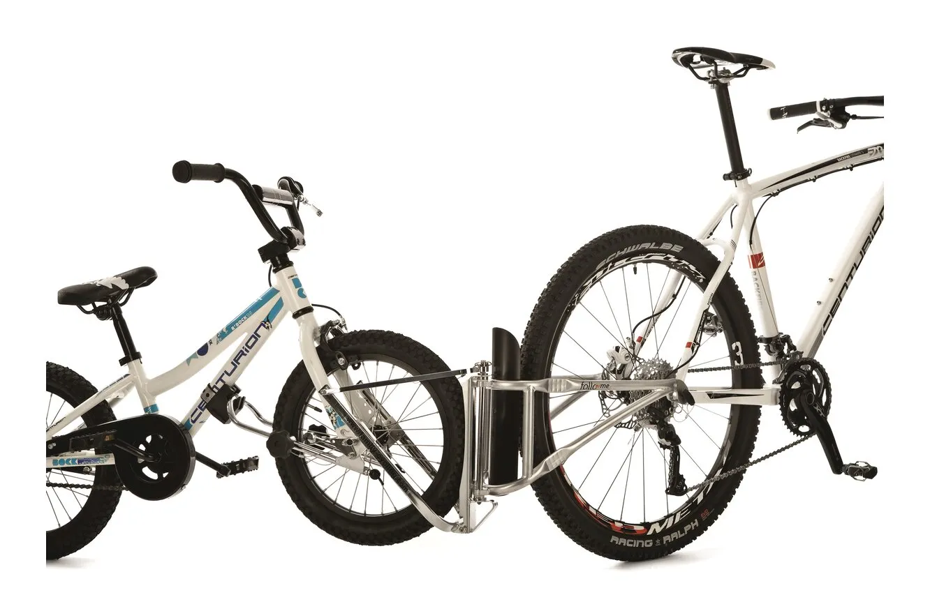 Ein weißes Erwachsenenfahrrad ist mit einer Tandemstange mit einem weißen Kinderfahrrad verbunden.