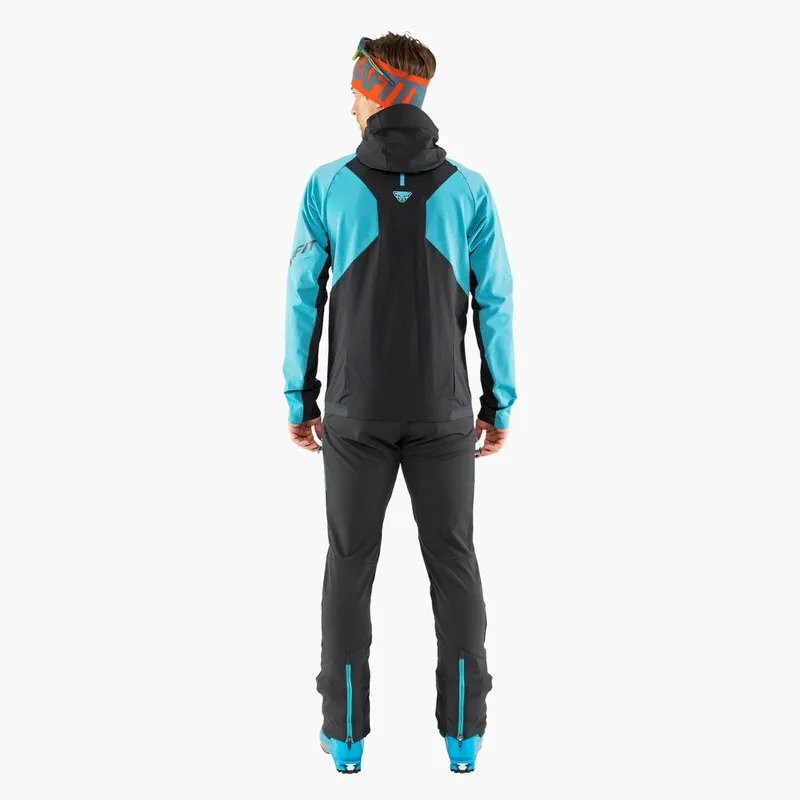 Man from behind, wearing blue Dynafit TLT Touring pants and jacket. Navy blue elements on jacket and pants.
