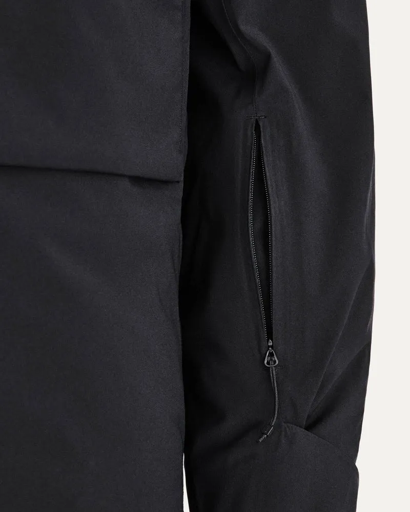 Detailaufnahme einer schwarzen Gore Tex 2L Stretch Jacke mit Reißverschlusstasche am Ärmel.