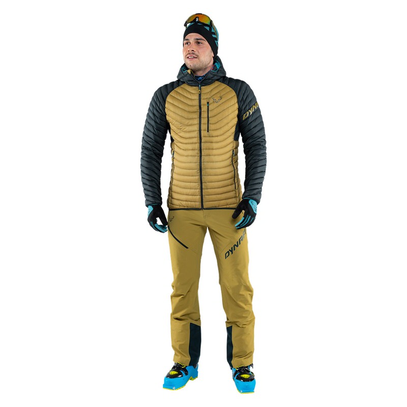 Mann trägt Dynafit Radical Daunenjacke in Blau-Beere/Army, Hose, Handschuhe, Mütze und Skischuhe.
