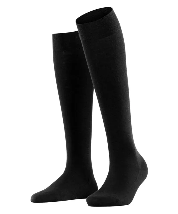 Two black, knitted knee-high socks made of merino wool, standing upright against a white background.