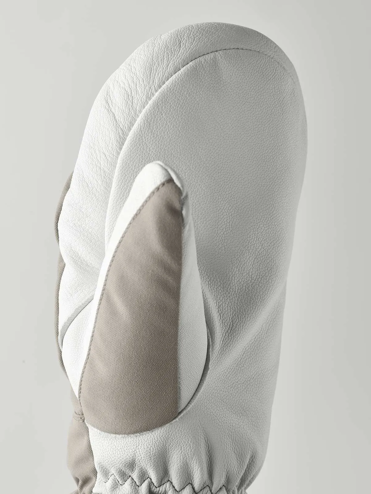 Detailansicht von Hestra Army Leather Heli Ski Mitt in Grau und Weiß. Lederstruktur ist erkennbar.