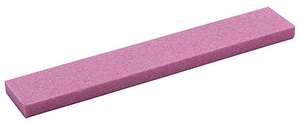 Rechteckiger Schleifstein in rosa Farbe, der diagonal im Raum liegt. Rauhe Textur ist erkennbar. Universal Edge Grinder.
