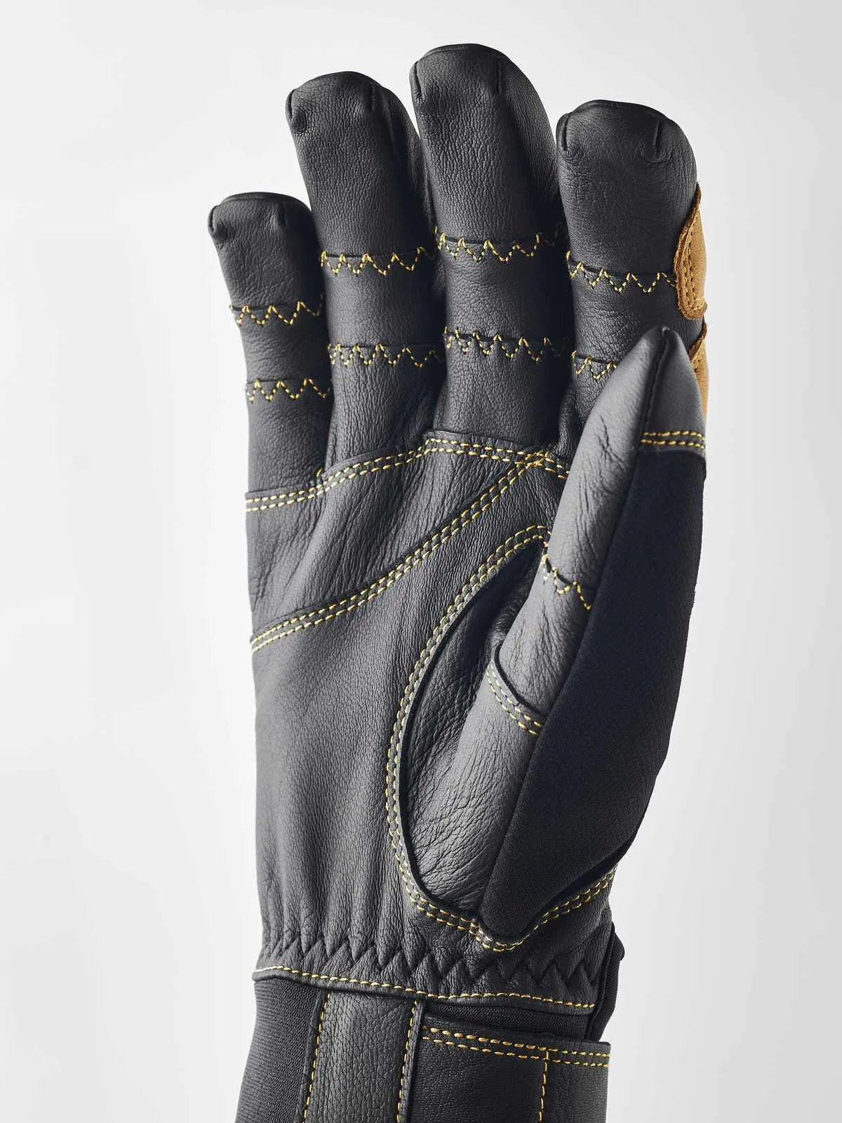 Schwarzer Hestra Ergo Grip Active Handschuh, Handfläche nach vorn, gelbe Nähte.