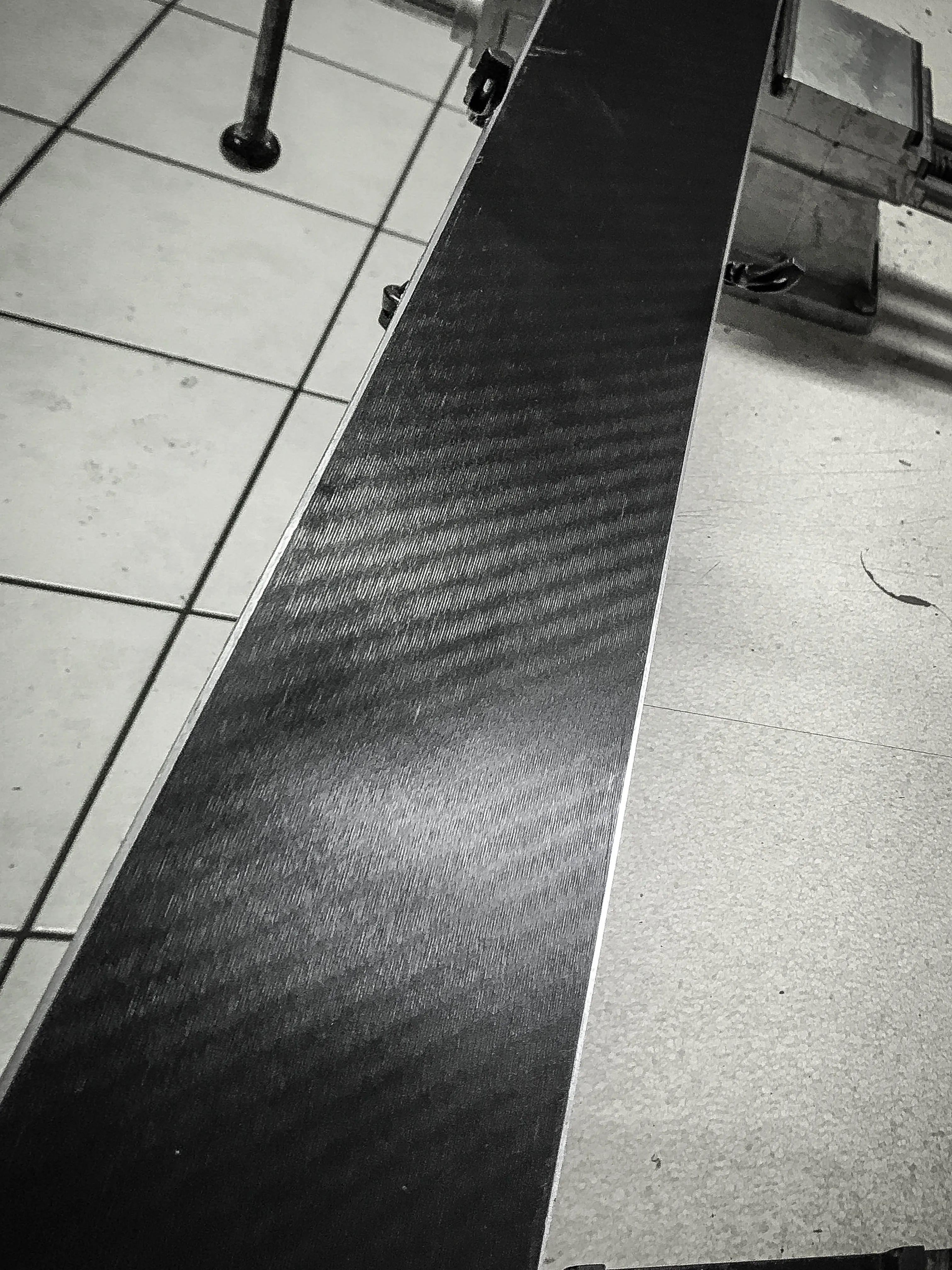 Primo piano di uno sci in bianco e nero. La superficie è caratterizzata da linee sottili e diagonali.