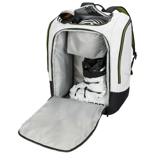 Geöffneter Head Rebels Racing Backpack 90L, gefüllt mit Skischuhen, Helm und Skibrille, Innenfächer sichtbar.