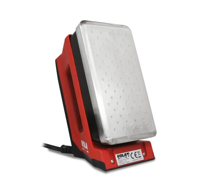 Red digital waxing iron with silver heating plate, standing on a black base.