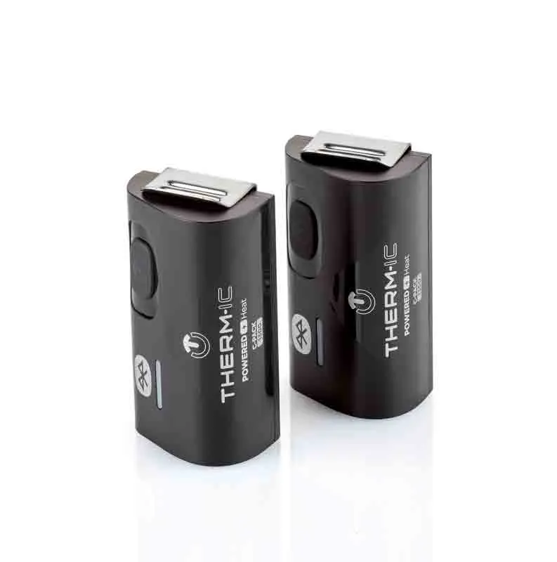 Zwei schwarze Therm-ic C-Pack 1300 B Akkus mit Metallaufsatz stehen auf einer weißen Oberfläche.