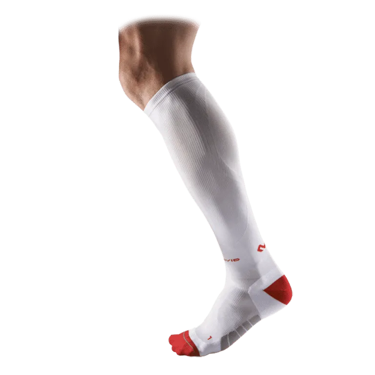 Chaussette blanche McDavid Compression Runner sur la jambe, contrastée en rouge sur les orteils et le talon.