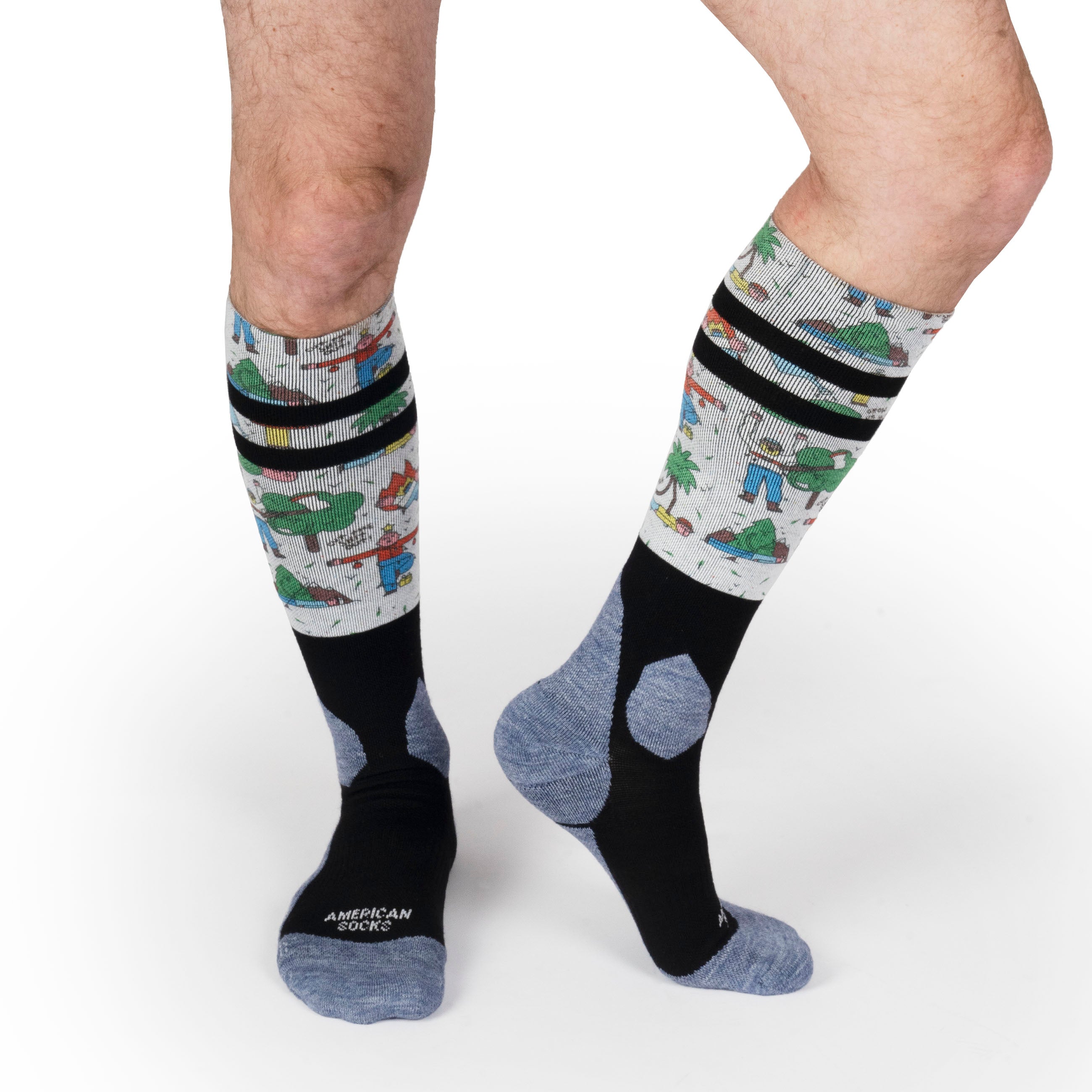"Leaf Me Alone Socken" Beine mit "Leaf Me Alone" Snow Socks, grau, schwarz, Motiv mit Comicfiguren und Palmen.