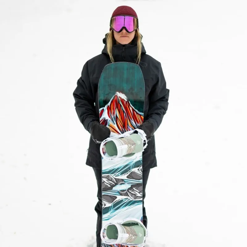Snowboarderin hält Twin Sister Snowboard mit Bergmotiv im Schnee.
