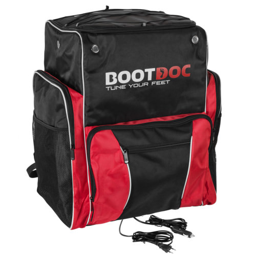 Schwarze/rote Bootdoc Skischuhtasche mit Tragesystem und seitlichem Netz. Zwei Stromkabel liegen vor der Tasche.