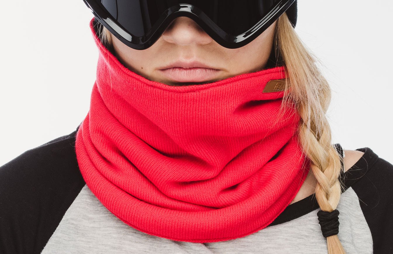 Frau mit Skibrille und rotem Schlauchschal bis zum Hals, geflochtene blonde Haare.