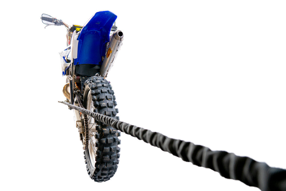 Motorrad wird mit einem Abschleppseil gezogen, Rückansicht, isoliert auf Weiß.