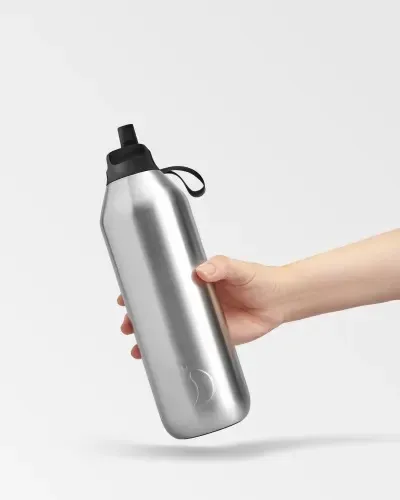 Une main tient une gourde argentée Chillys Series 2 Flip Stainless Steel 1L sur un fond blanc.