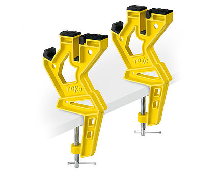 Vise-skis jaune Toko  Jaune Toko Ski Vise Dispositif de serrage express, deux pièces, fixé sur une surface blanche.