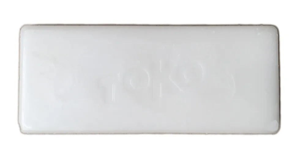 Rectangular, white wax block with the lettering "TOKO" lightly embossed.