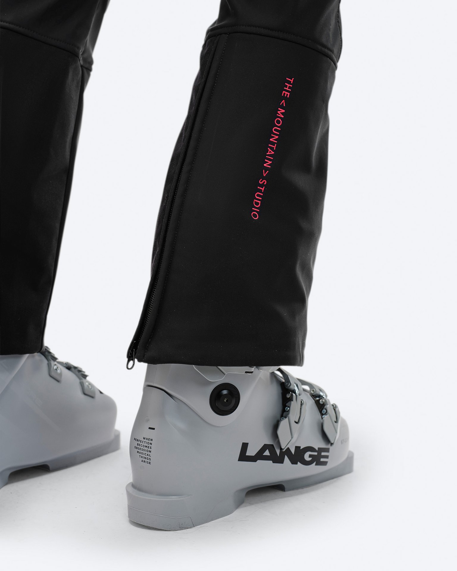 Black P-4 W 2L ski pants Close-up of the black P-4 W 2L stretch ski pants with ski boot. Zipper at the leg end and logo visible.