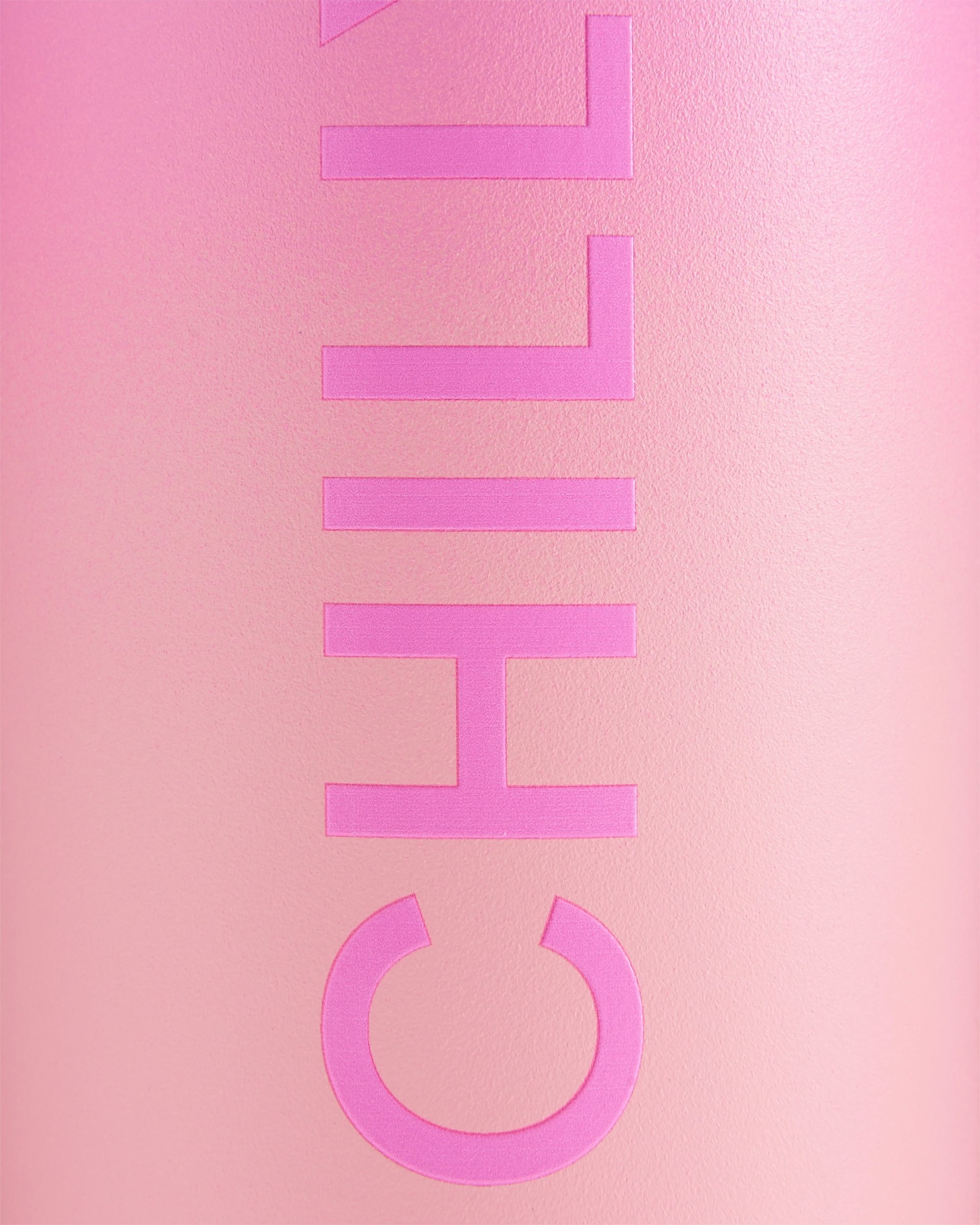 Gros plan sur une bouteille rose Chillys Series 2 Flip Bottle avec le logo en relief sur un fond rose ombré.