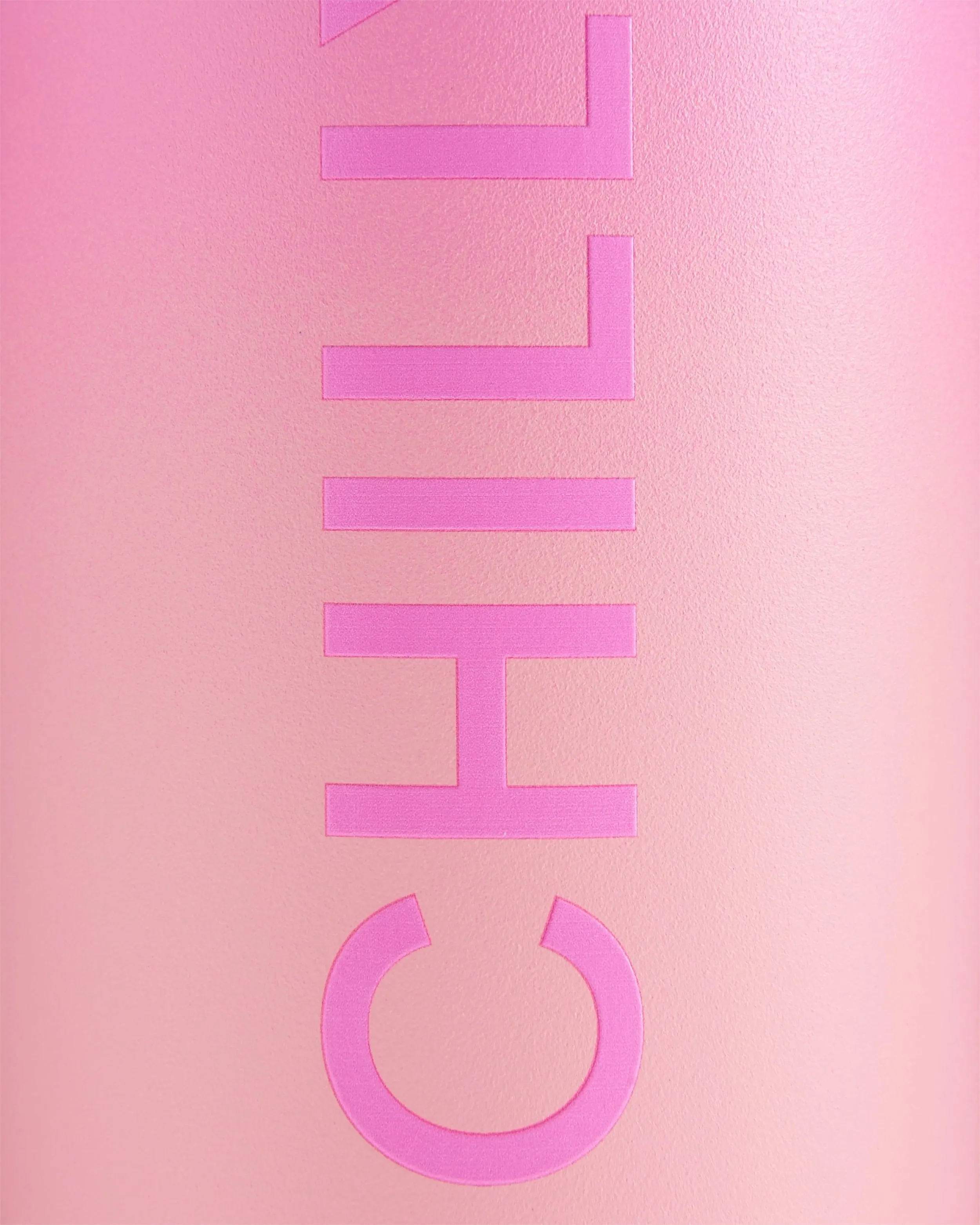 Close-up of a pink Chillys Series 2 Flip Bottle with raised logo on a pink ombre background.