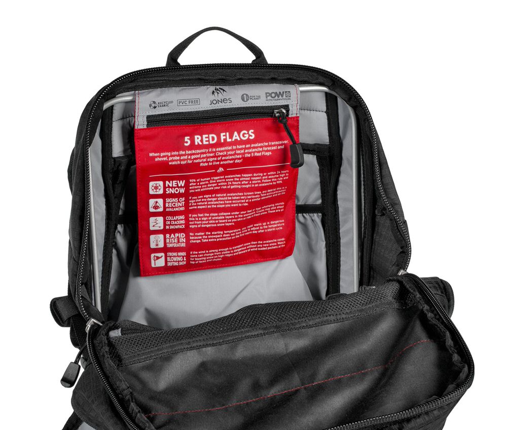 Offener Rucksack mit Sicherheitshinweisen Offener DSCNT RAS Rucksack mit Lawinensicherheits-Hinweisen auf rotem Stoff.