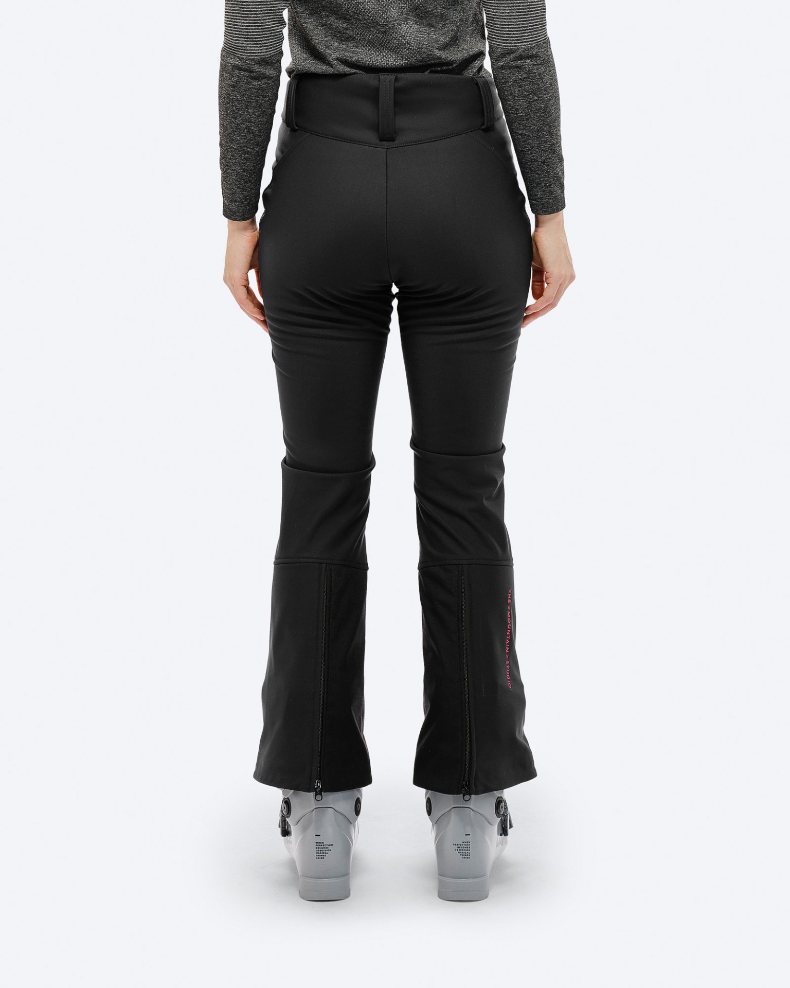 Black stretch ski pants Rear view: Black P-4 W 2L stretch ski pants with ski boots and pink logo on the leg cuffs.
