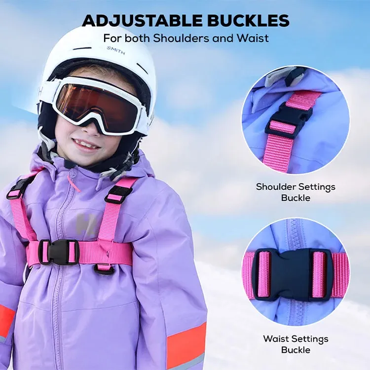 A smiling toddler wearing a pink ski harness with adjustable buckles over a purple ski jacket and white helmet. Close-ups of the shoulder and waist buckles are shown to highlight the adjustability and functionality.