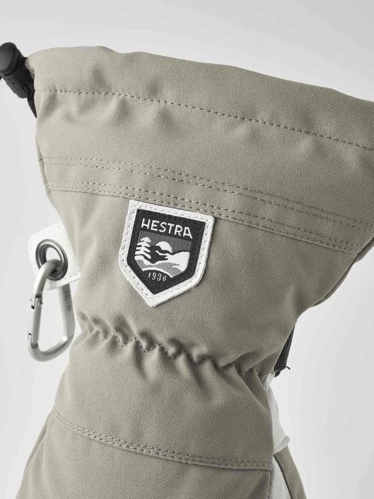Detailaufnahme des Hestra Army Leather Heli Ski Mitt, mit Logo und Karabinerhaken.