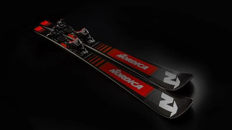 Un paio di sci Nordica Ski neri con accenti e attacchi rossi si trovano in diagonale su uno sfondo nero.