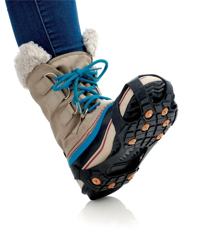 Boots with blue laces and Sidas Walk Traction shoe claws with orange spikes on the sole.