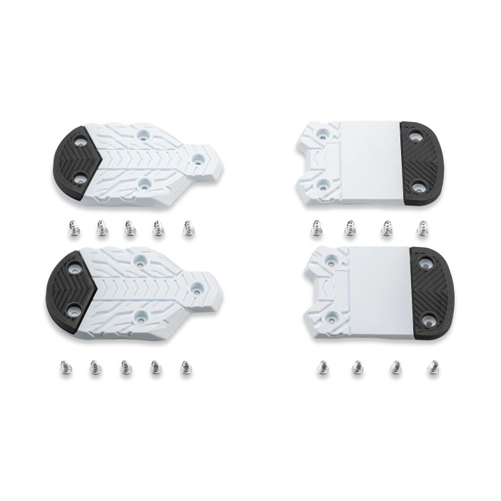 Four ski binding plates, with screws, in white and black, arranged in pairs. Two plates are rounded, two are rectangular.