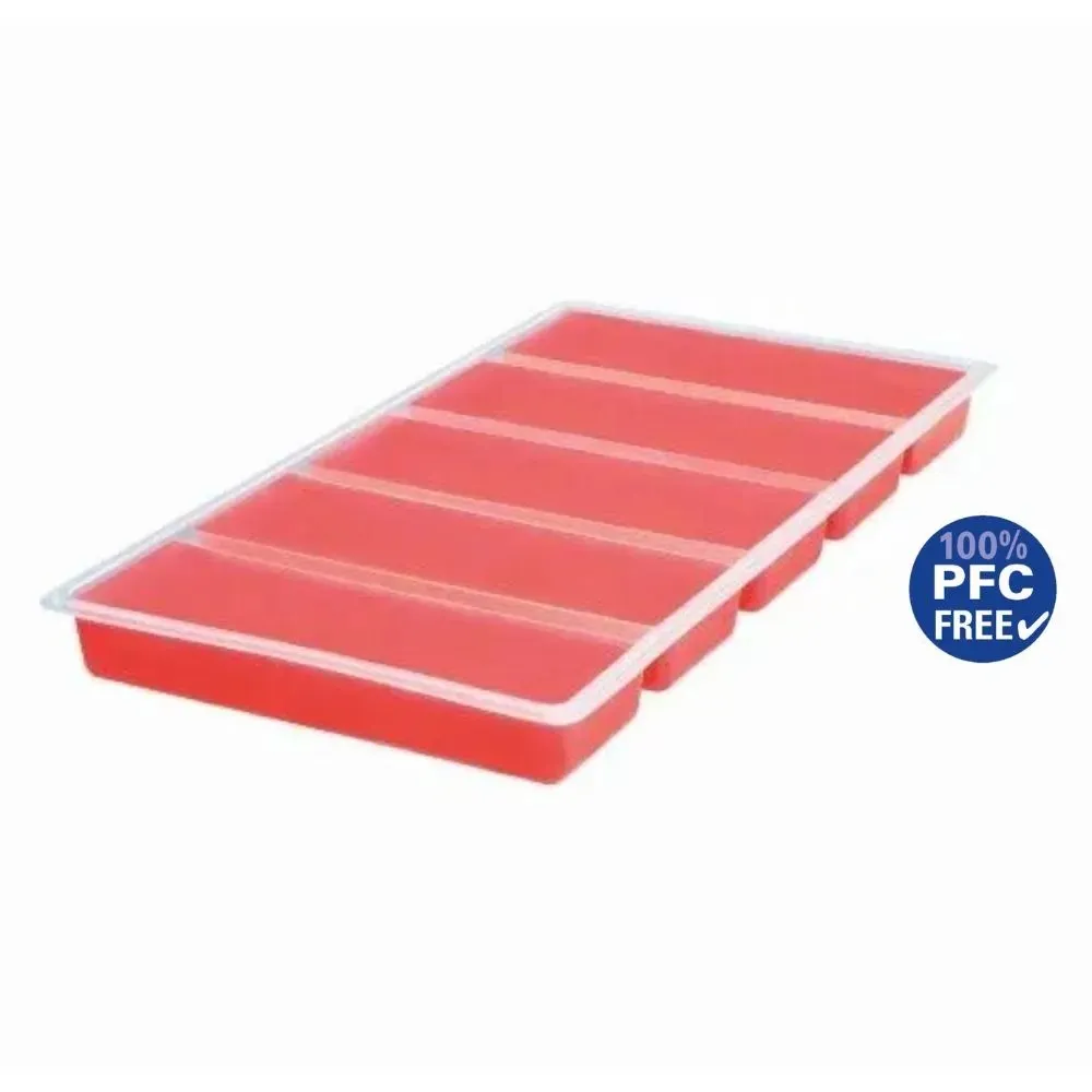 A red ice cube tray with six elongated compartments and a transparent lid is shown diagonally on a white background. In the lower right corner, there is a blue round label with "100% PFC FREE" and a checkmark.