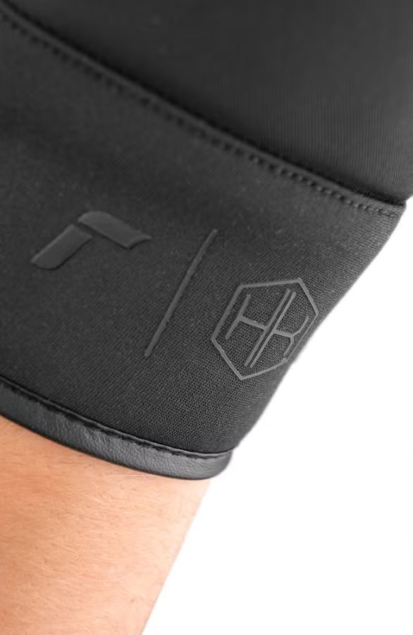 Nahaufnahme des Reusch Henrik Kristoffersen Handschuhs mit Logos und Ledereinfassung am Handgelenk.
