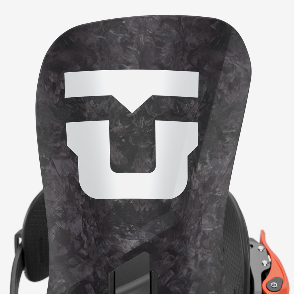 Schwarze Snowboardbindung mit weißem Logo und orangefarbenen Details vor einem weißen Hintergrund.