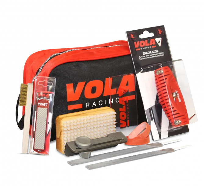 Vola Tuning Kit Plus: Tools such as file, brush, edge planer and sanding stone in front of a red bag with Vola logo.