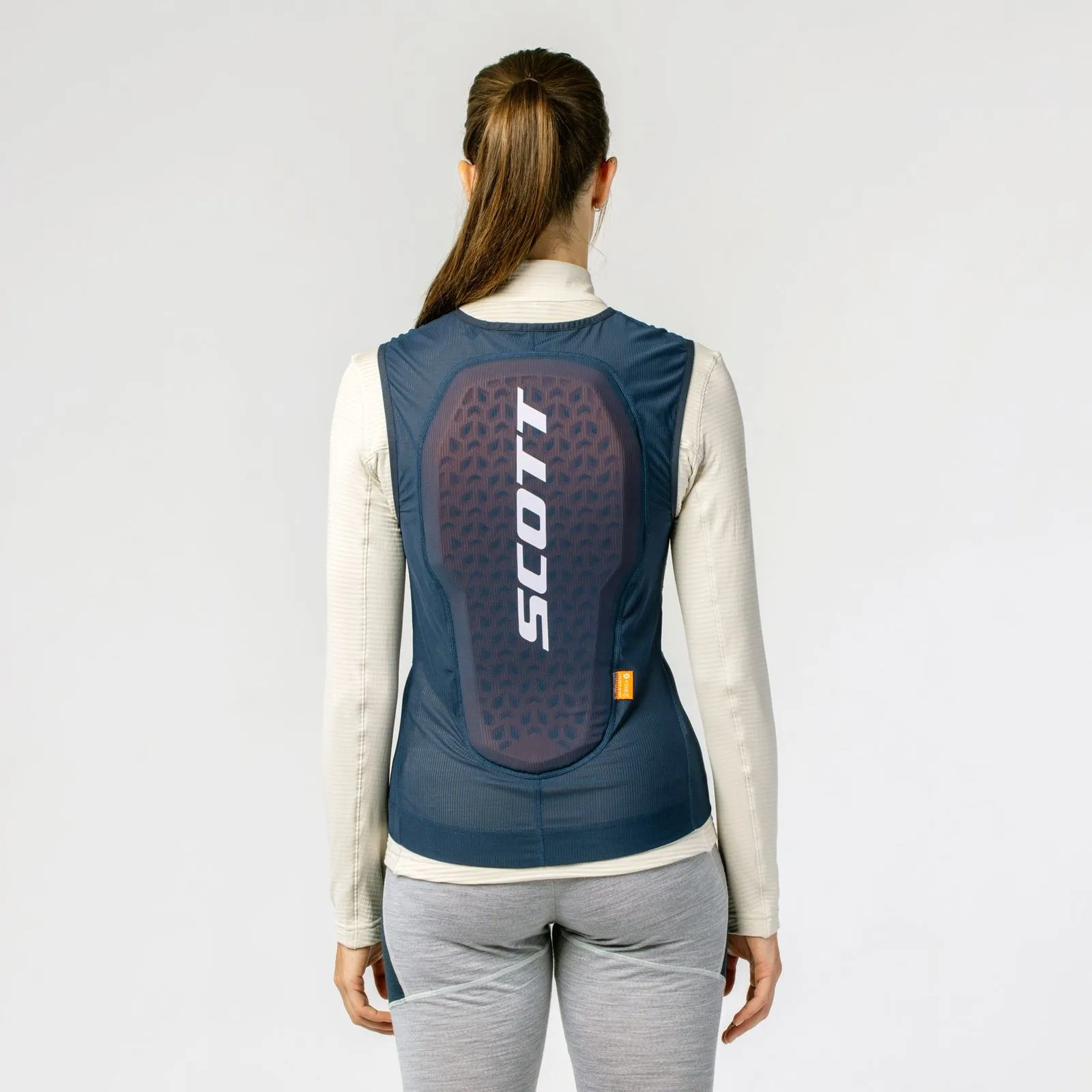 Back view of a woman with Scott Airflow vest in blue/white. The vest has a back protector with a large Scott logo.