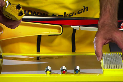 Appareil de structuration jaune et noir pour skis avec rouleaux de structuration interchangeables et colorés.