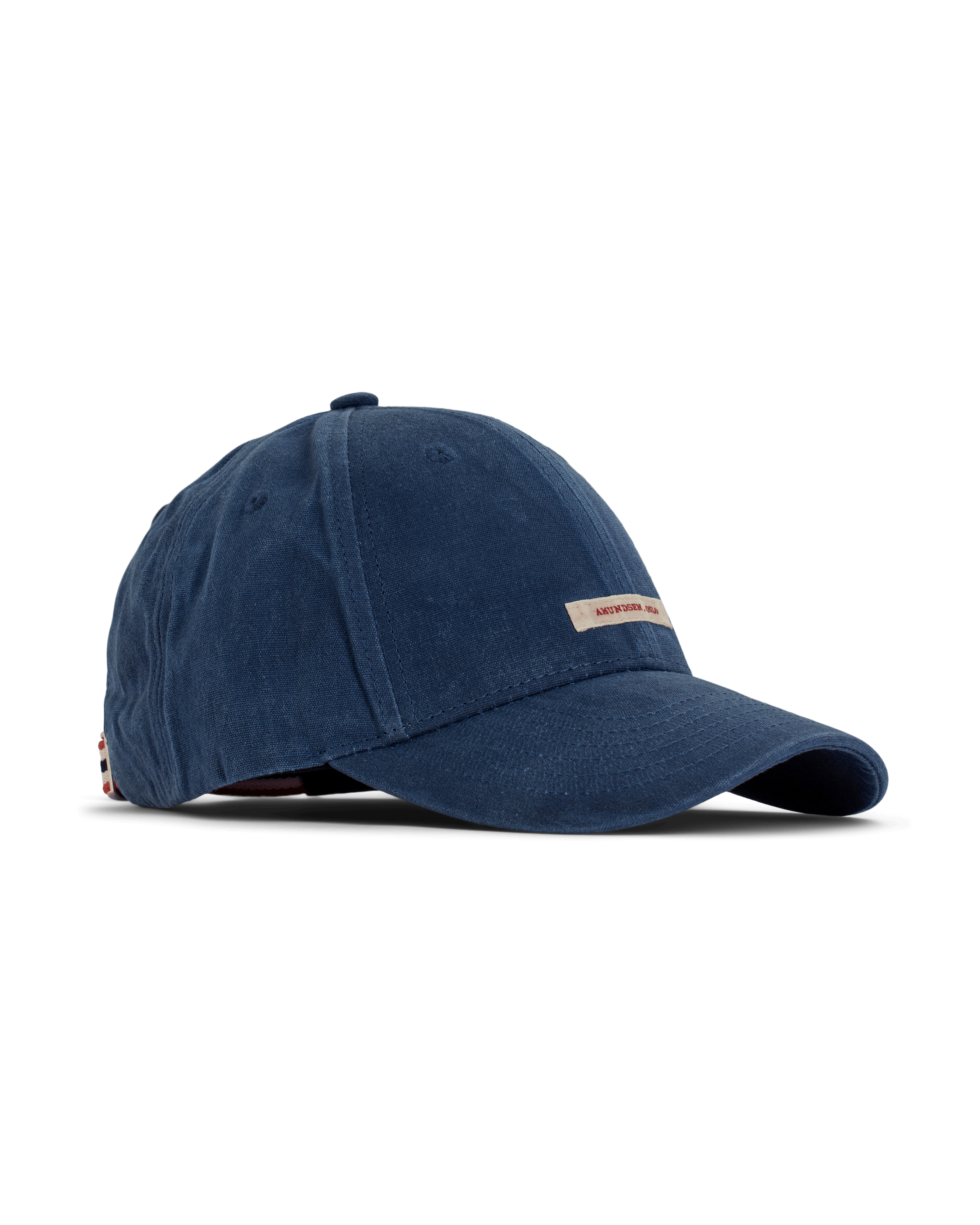 A dark blue " Amundsen " waxed cotton cap with a white background and a small beige logo above the brim. The cap is crafted from waxed fabric. The product image is captured from the side to clearly showcase its shape.
