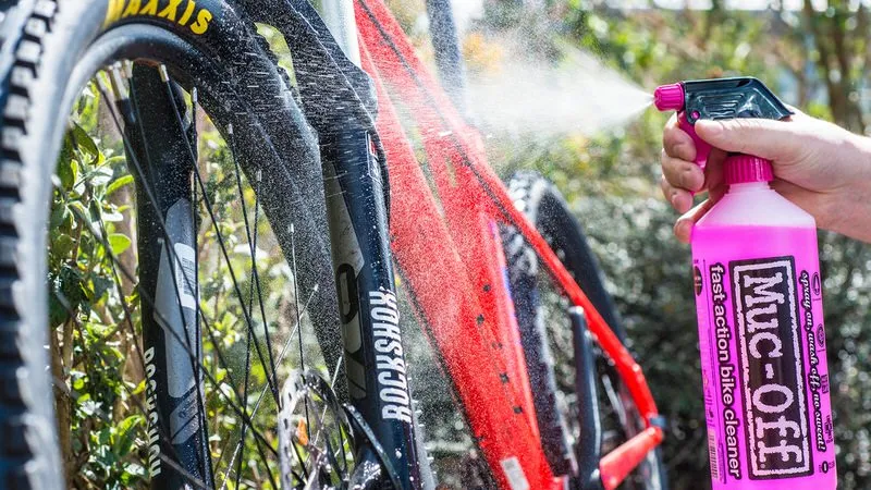 Reinigung eines Fahrrads mit Muc-Off Nano Tech Reiniger aus rosa Sprühflasche. Fahrrad wird sauber gesprüht.