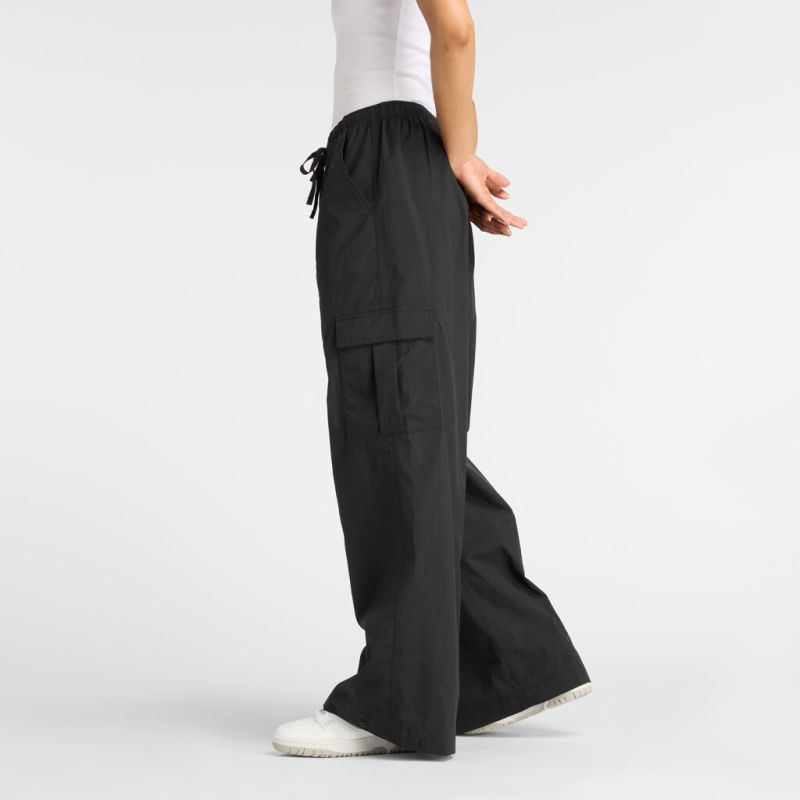 Schwarze Cargo Pants Eine Person trägt eine schwarze New Balance Cargo Pant. Die Hose hat einen Kordelzug und Cargotaschen.