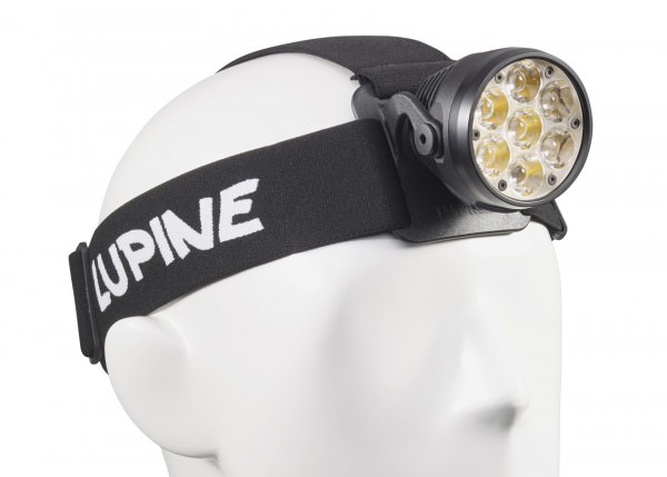 Nahaufnahme einer Betty RX7 Stirnlampe mit sieben LEDs auf einem weißen Kopfmodell. Das Stirnband ist schwarz mit weißer Schrift.
