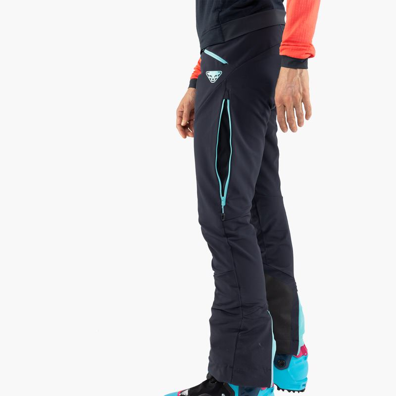 Vue détaillée du pantalon Dynafit TLT Touring DST Women en bleu, fermeture éclair latérale et logo visible.