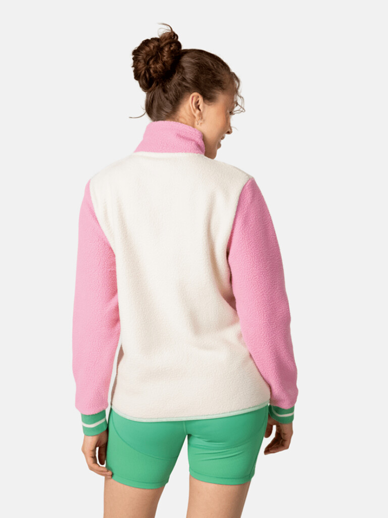 Rothe Midlayer Model Rückansicht Rückansicht eines Models im Rothe Midlayer: Rosa Ärmel, cremefarbener Rumpf und grüne Shorts.