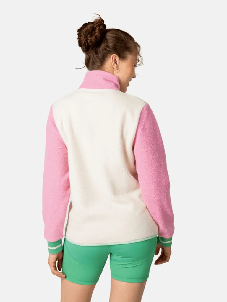 Back view of a model in the Rothe Midlayer: pink sleeves, cream-colored torso and green shorts.