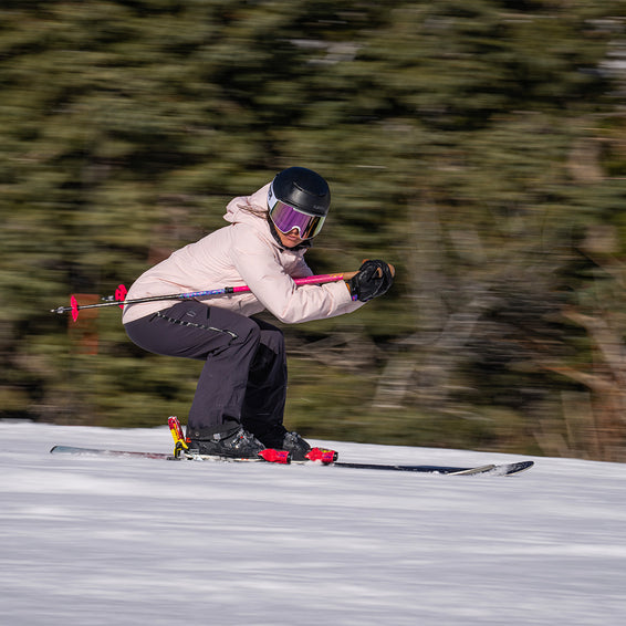 Skieuse avec masque Proform Skieuse sur les pistes avec un masque Miami Nights Proform rose, arrière-plan flou.