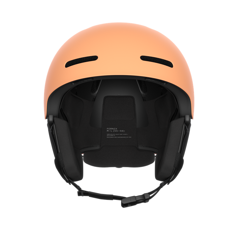 Pfirsichfarbener Skihelm von vorne, mit schwarzen Belüftungsschlitzen und Ohrpolstern. Kinnriemen sind unterhalb sichtbar.